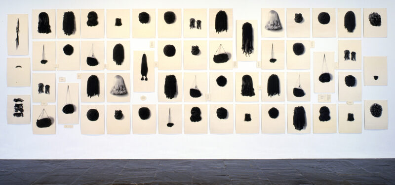 Lorna Simpson Wigs II, 1994-2006 Serigraph on 71 felt panels (images and text) 98 x 265 in overall. Courtesy the artist, Salon 94, New York; and Galerie Nathalie Obadia, Paris / Brussels © Lorna Simpson