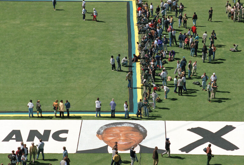 Greame Williams: Portrait of Nelson Mandela painted on the grass of Soweto’s largest football stadium during an election rally, 1994 Courtesy the artist © Greame Williams