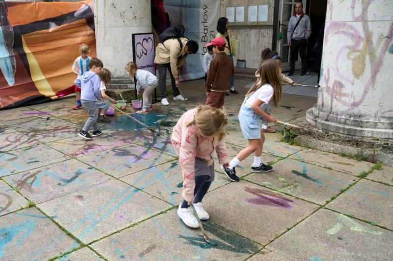 Kinder bemalen einen Steinboden.