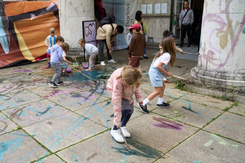 Kinder bemalen einen Steinboden.
