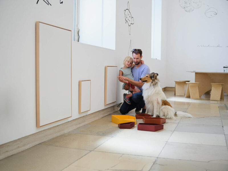 Familie mit Hund vor einer Leinwand