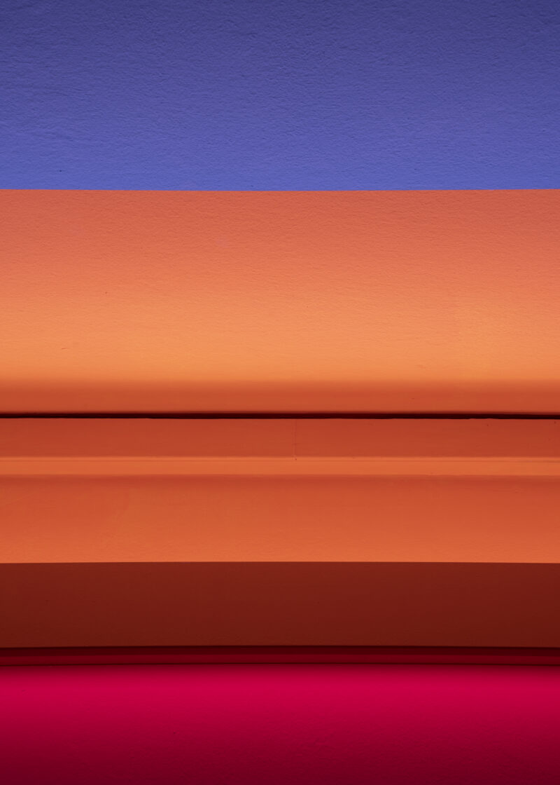 Blauer streifen über orangenem Streifen über pinkem Streifen.