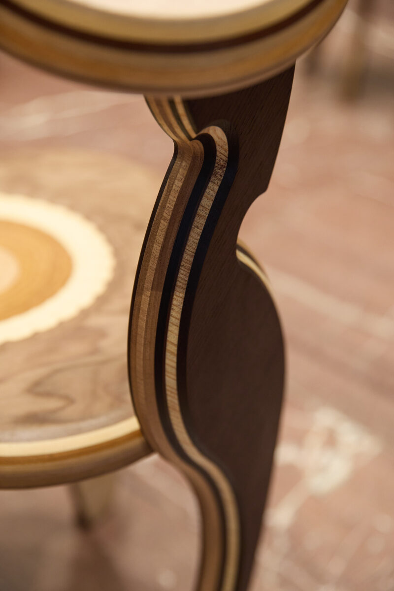 Eine Detailaufnahme von den verschiedenen aneinander gelaimten Hölzer des Stuhls.