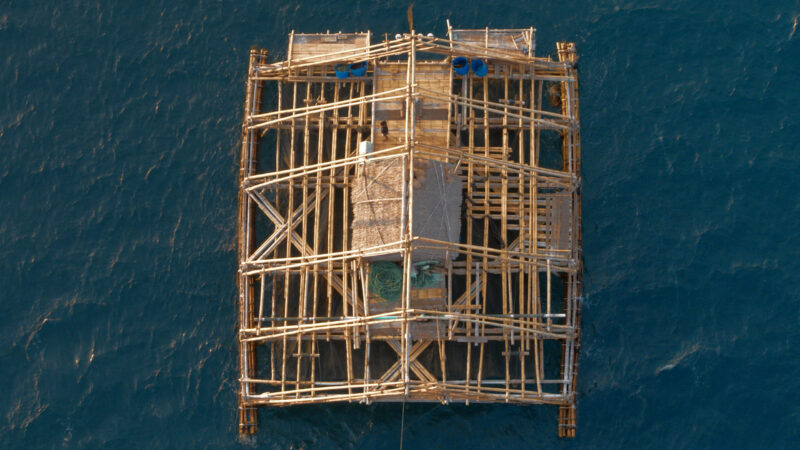 A wooden structure is floating in the sea.