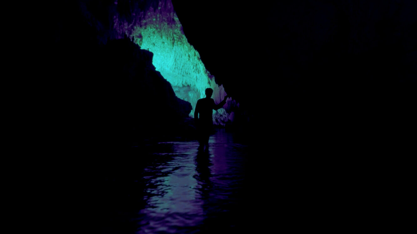 A silhouette in a cave with water