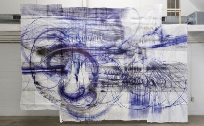 Weiße Tüche hängen von der Decke mit blauen Zeichnungen darauf.