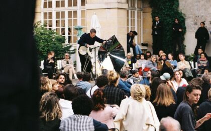 Menschen beobachten eine Person mit einem Instrument.