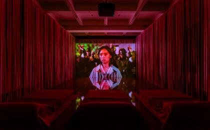 In einem roten Kinosaal wird ein Film abgespielt.