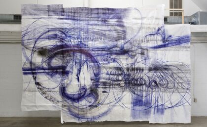 Weiße Tüche hängen von der Decke mit blauen Zeichnungen darauf.