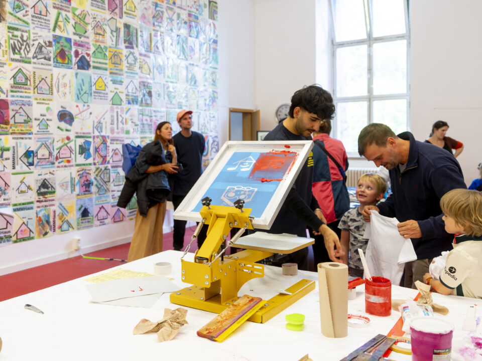 Erwachsene und Kinder beim Siebdrucken