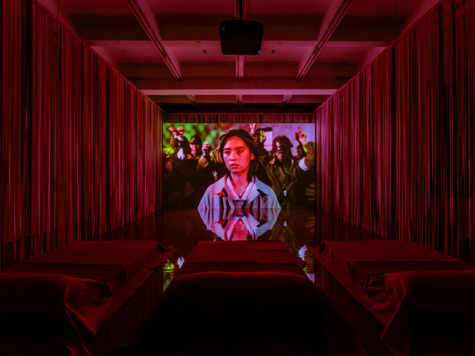 In einem roten Kinosaal wird ein Film abgespielt.