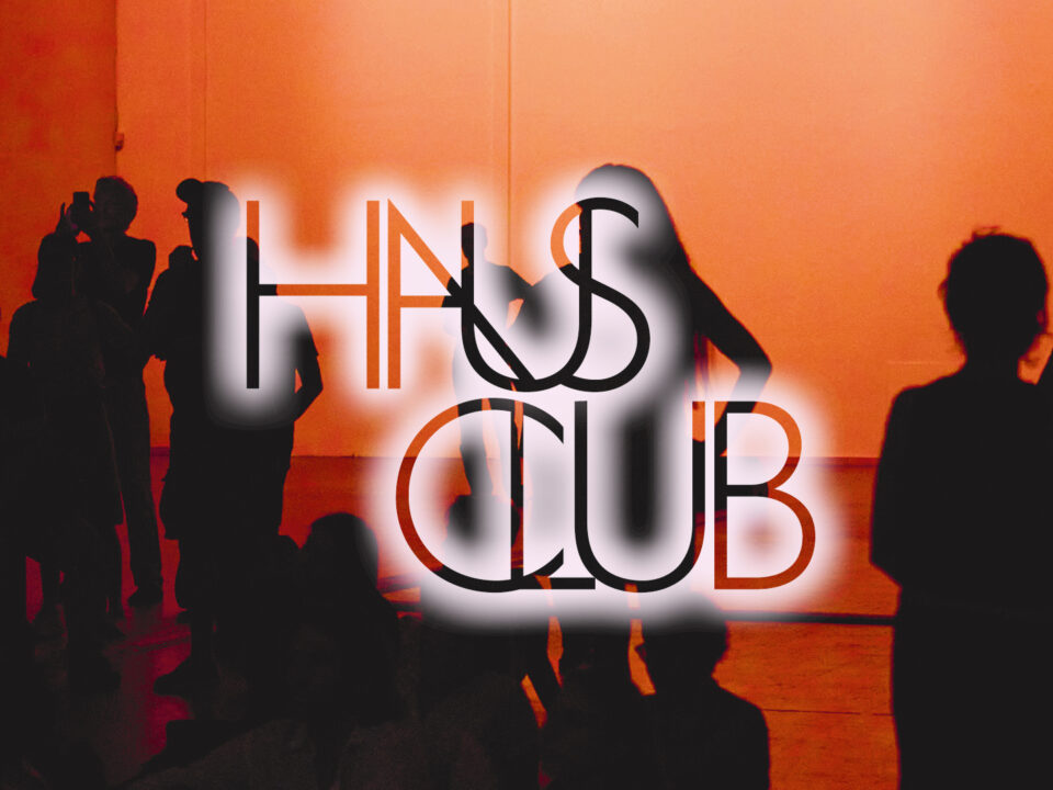 Dunkle Silhouetten von Menschen, die vor einer rot beleuchteten Bühne stehen und sitzen. Der Schriftzug "Haus Club" ist auf dem Bild zu sehen.