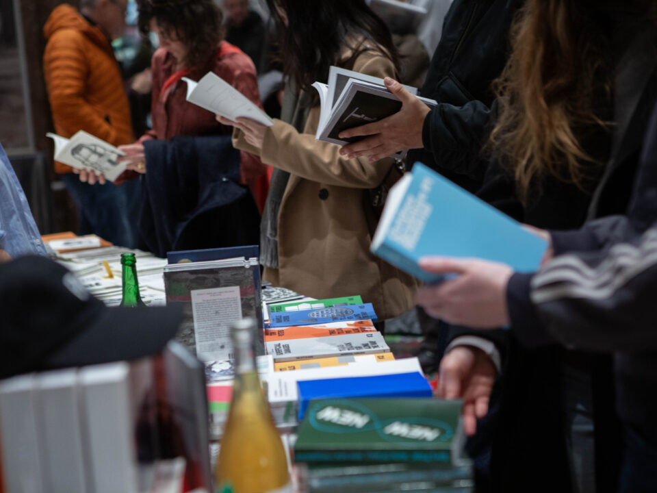 Menschen schauen an einem Stand Bücher und Zeitschriften durch.